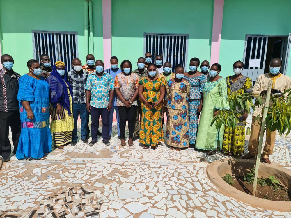 Group poses for photo outside wearing face masks